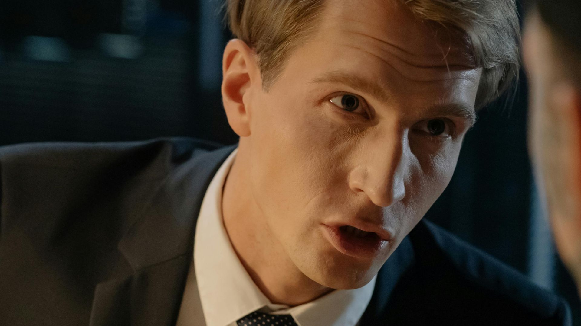 Close-up of a professional man in a suit engaged in a serious discussion.