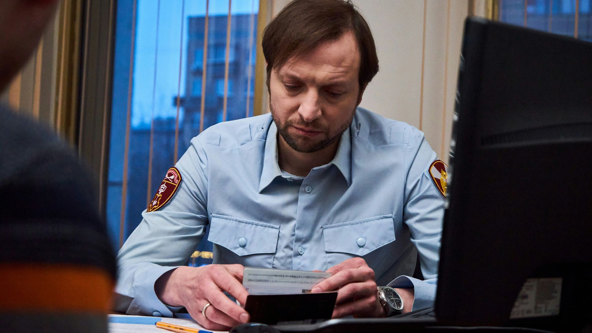 woman in blue button up shirt sitting at the table