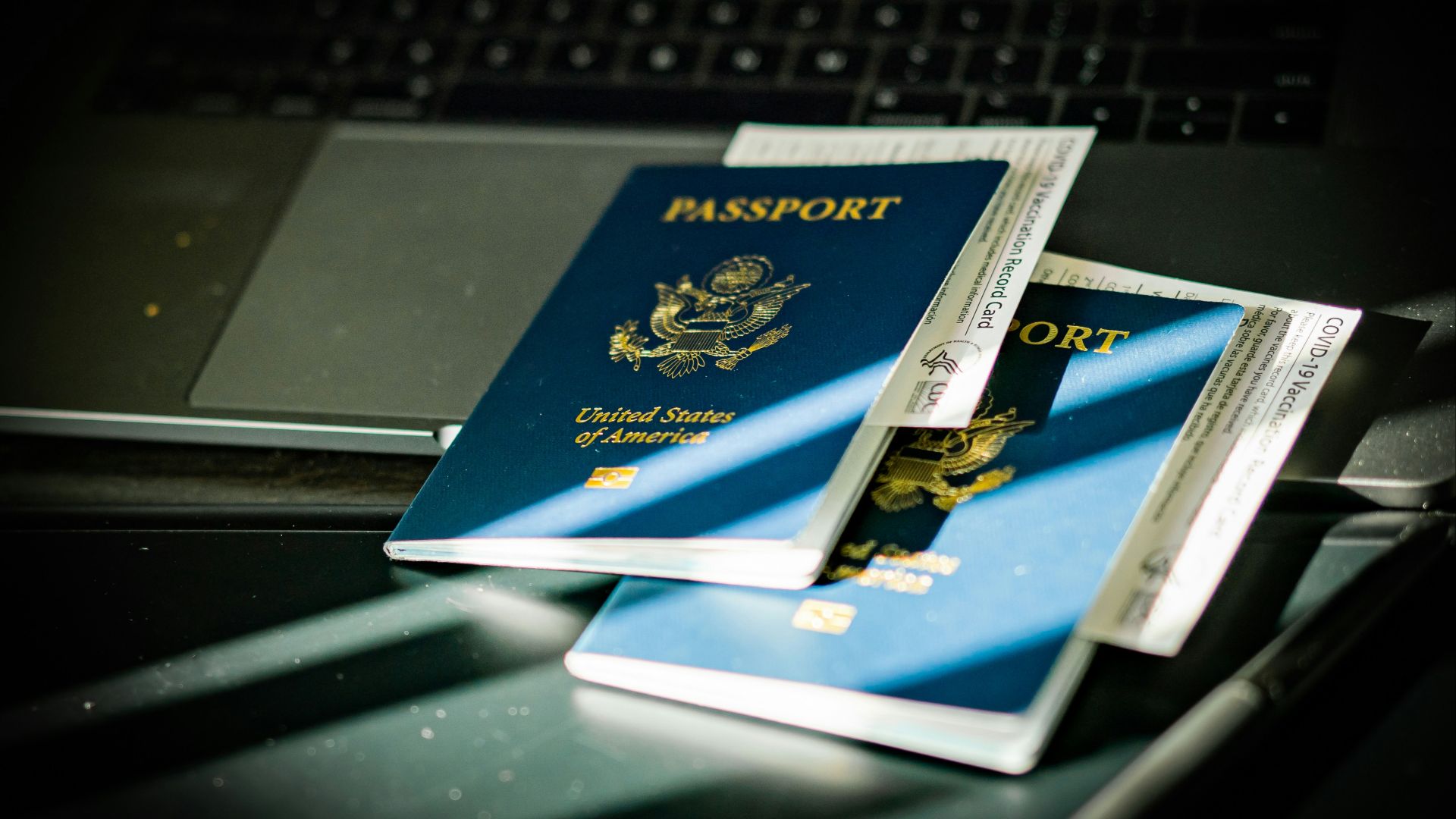 a passport sitting on top of a computer keyboard