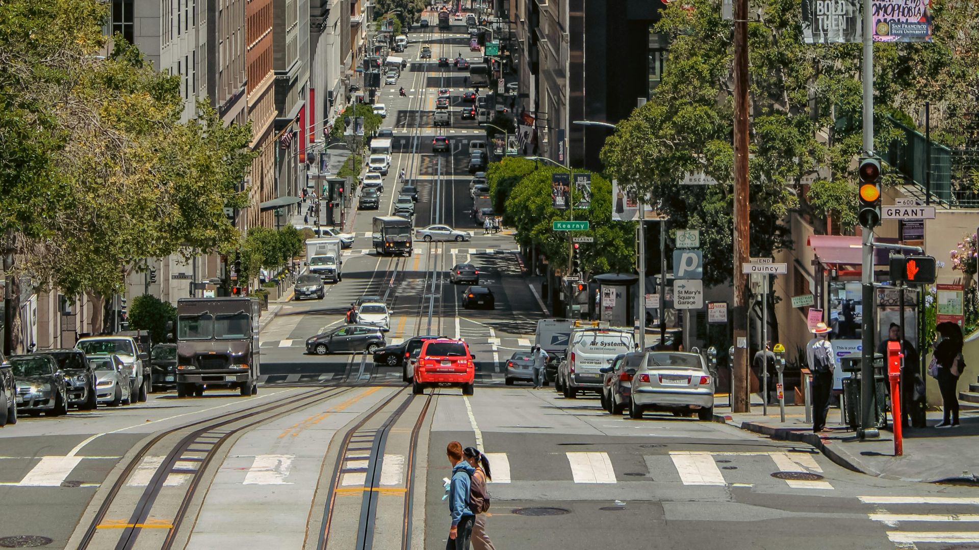 Vibrant street view of San Francisco with iconic bridge in background.