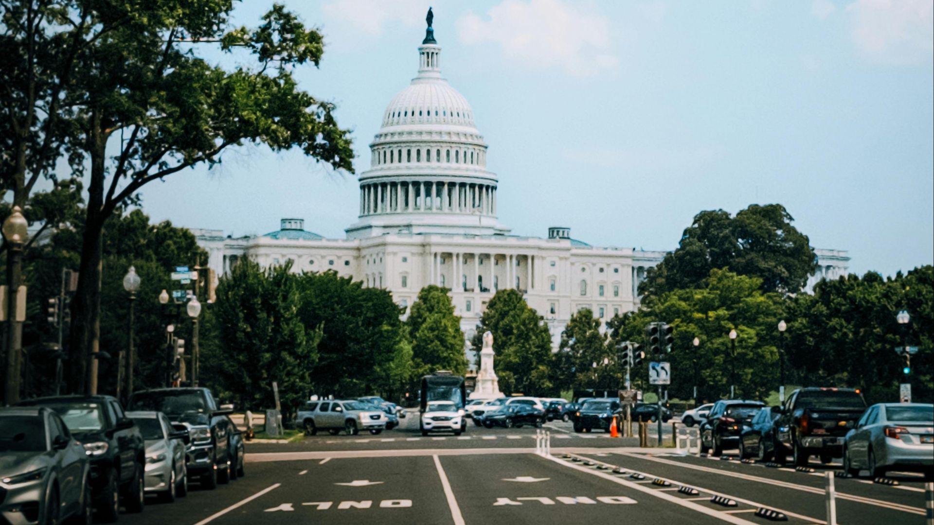 Wide view of the United States Capitol with a clear sky, prominently featuring the iconic architecture.
