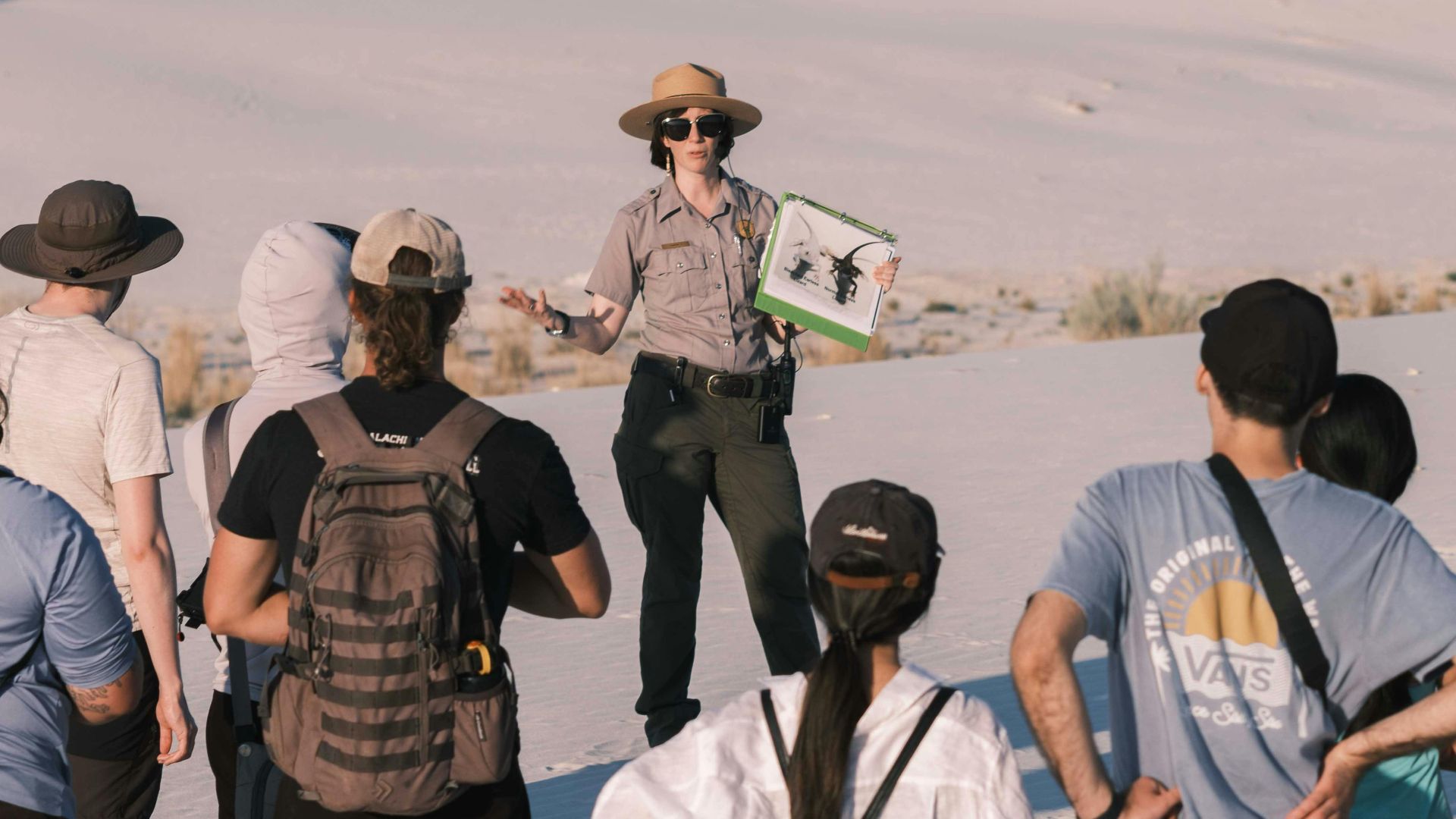 Group of tourists with a guide exploring White Sands National Park during daytime.