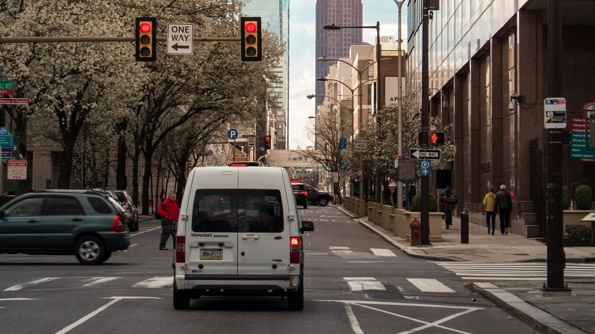 A bustling Philadelphia street featuring traffic, skyscrapers, and urban architecture.