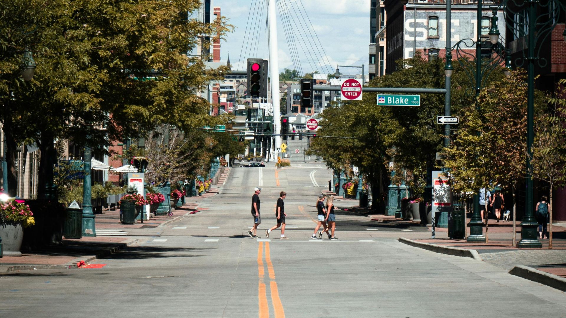 Urban view of Denver's Millennium Bridge with people walking. Bright day and clear sky.