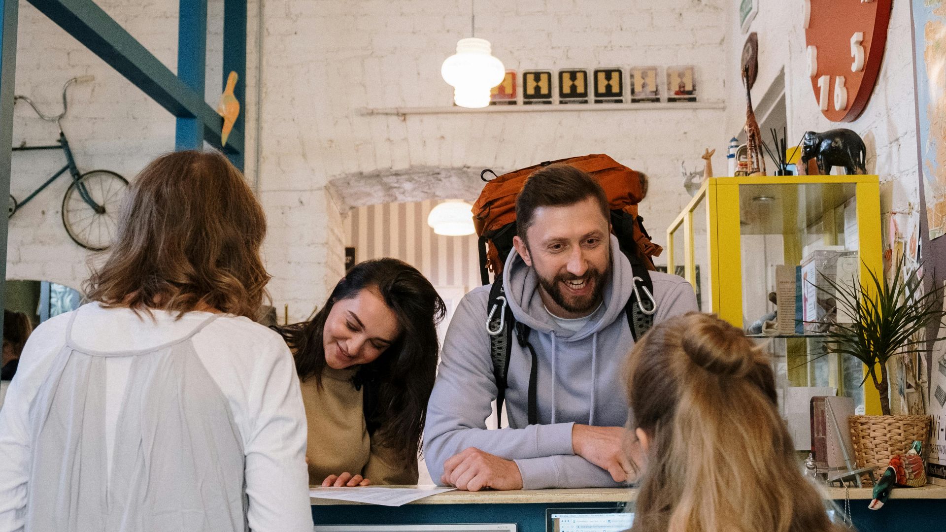 Backpackers cheerfully checking in at a vibrant hostel reception desk.