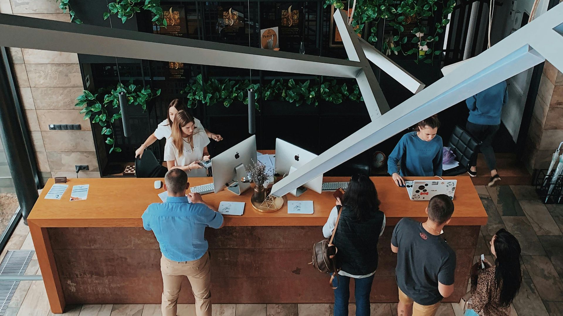 Aerial view of a modern hotel reception with people interacting at the desk in Sosnivka, Ukraine.