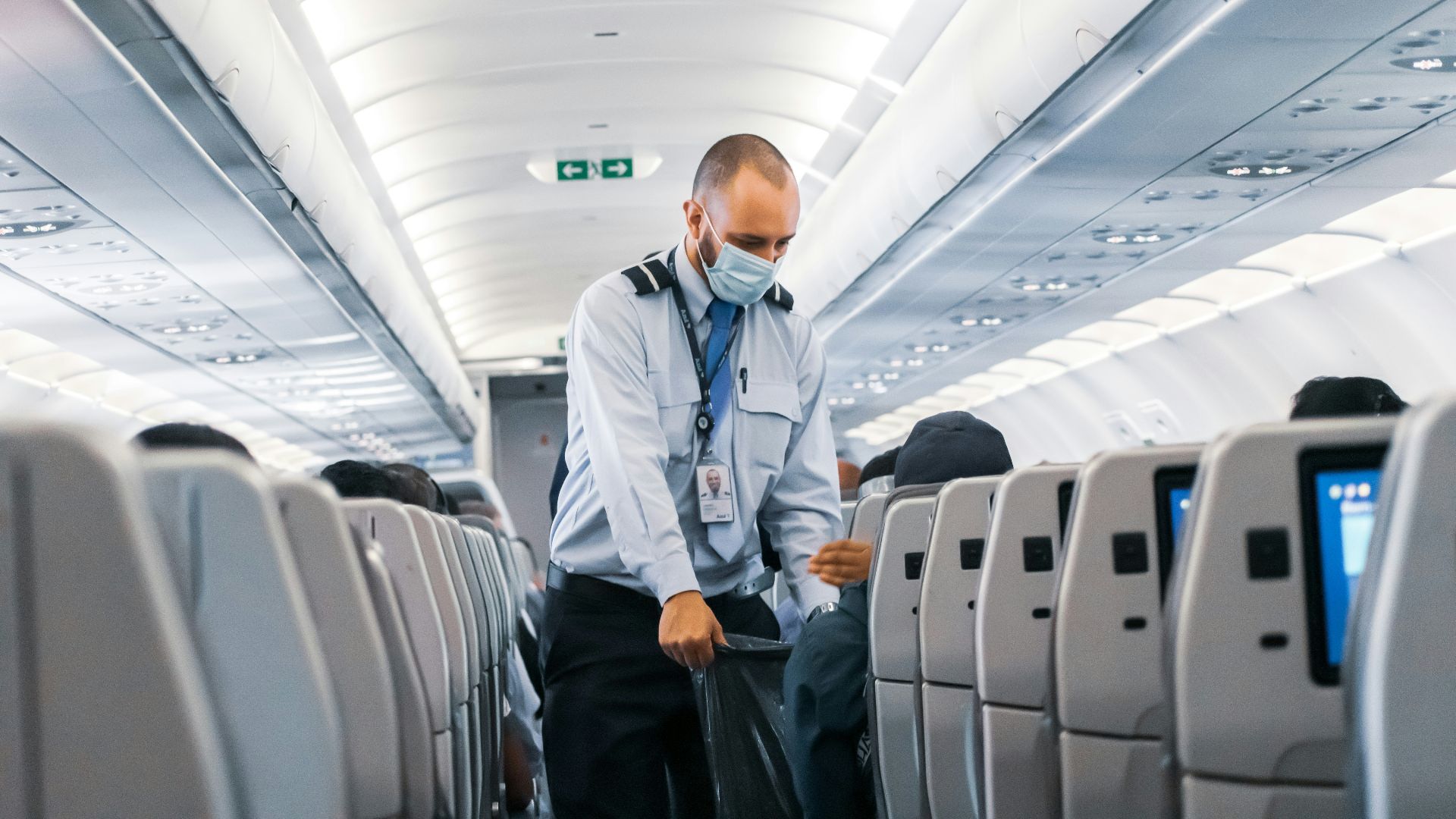 man in blue dress shirt standing in airplane