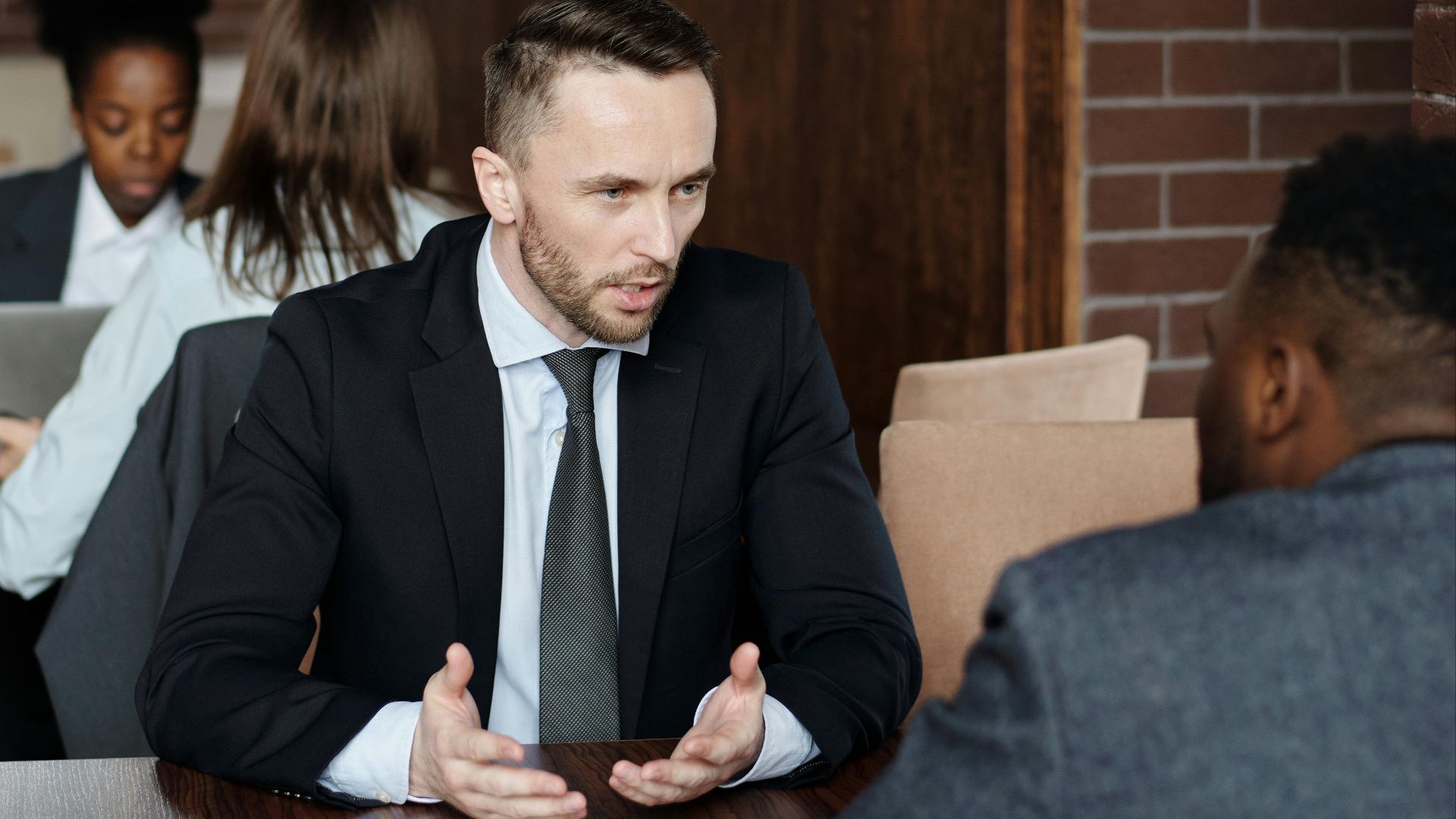 Professionals in suits having a focused business discussion in a stylish café.