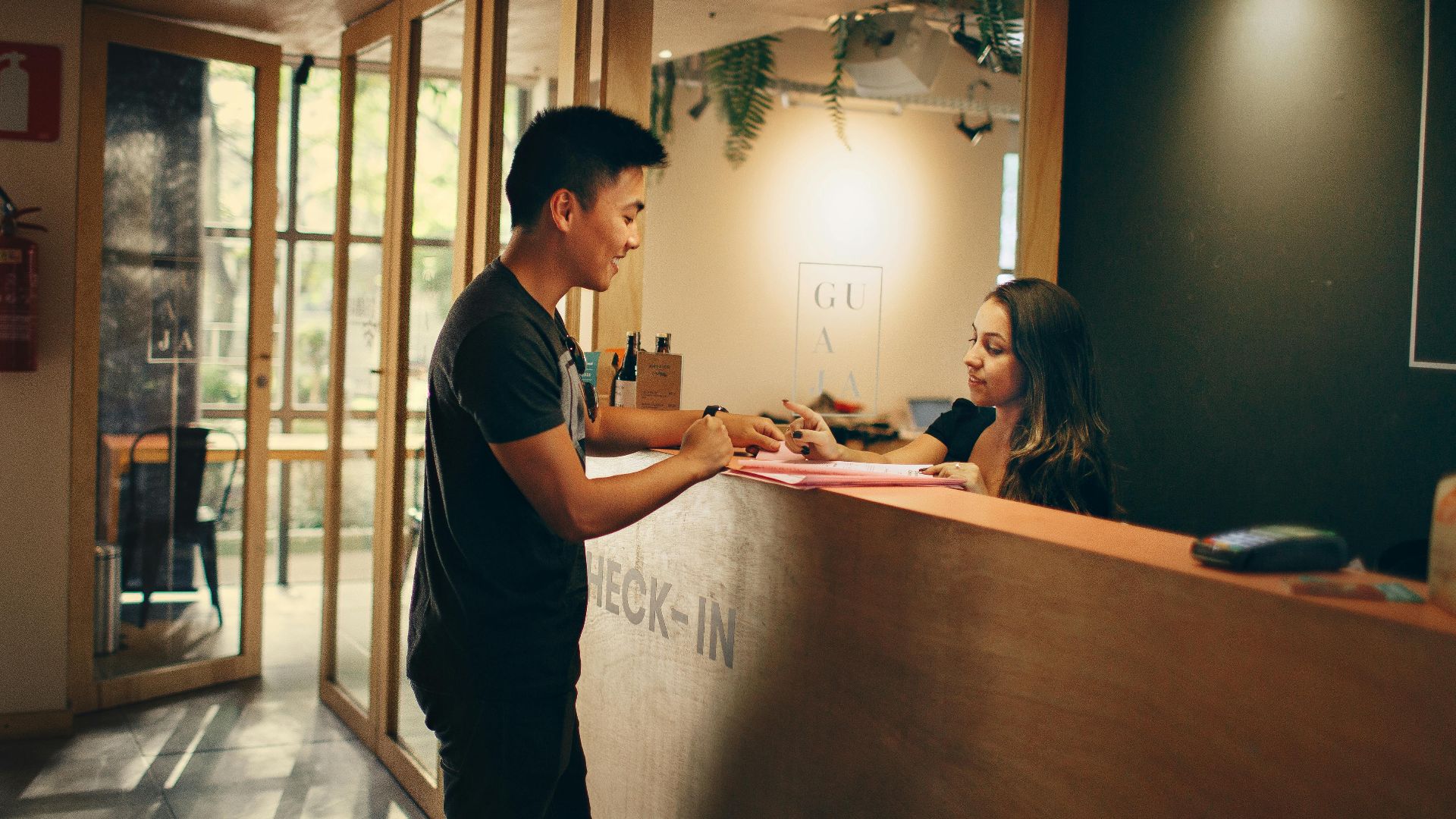 A customer checks in at a hotel reception desk in Belo Horizonte, Brazil.