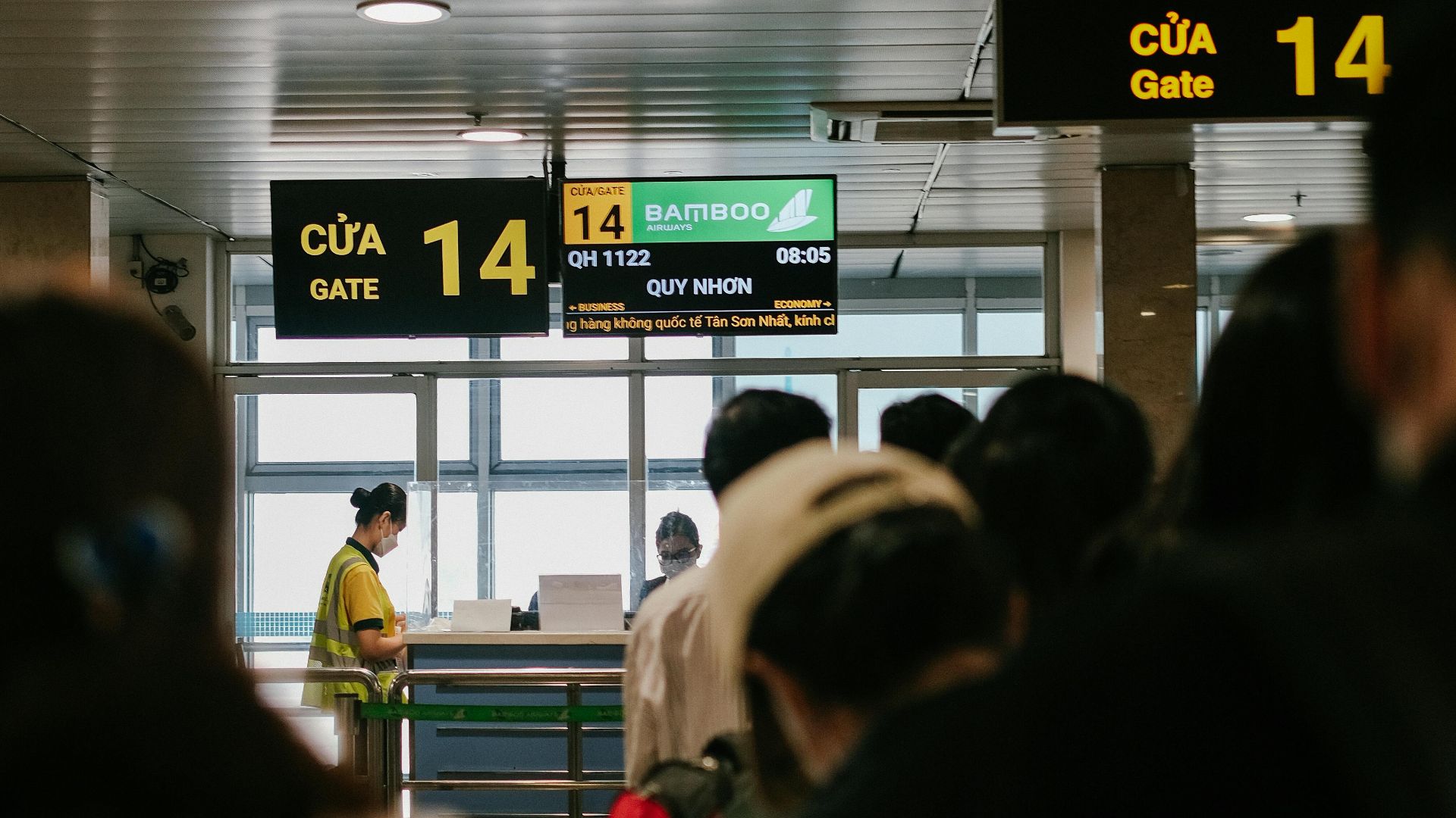 People standing in line at an airport gate, waiting to board a flight.