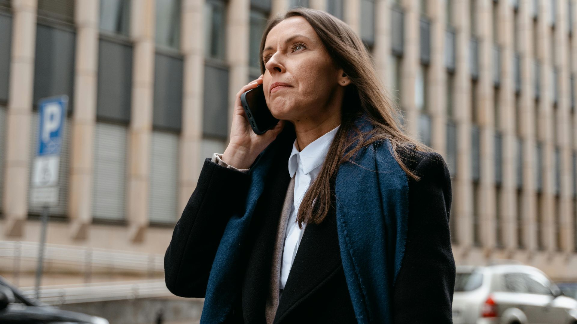 Confident businesswoman talking on the phone in the city street.