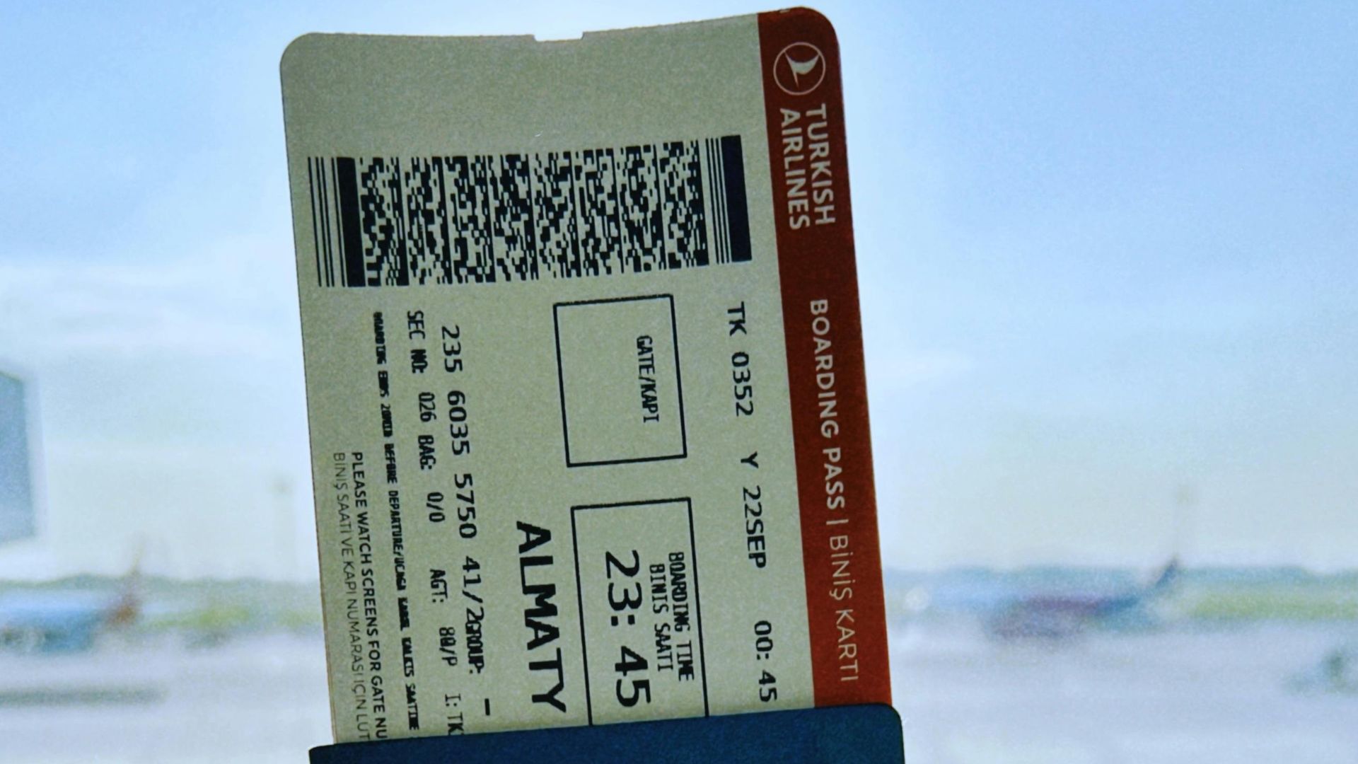 Kazakhstan passport with boarding pass in Warsaw airport, ready for travel.