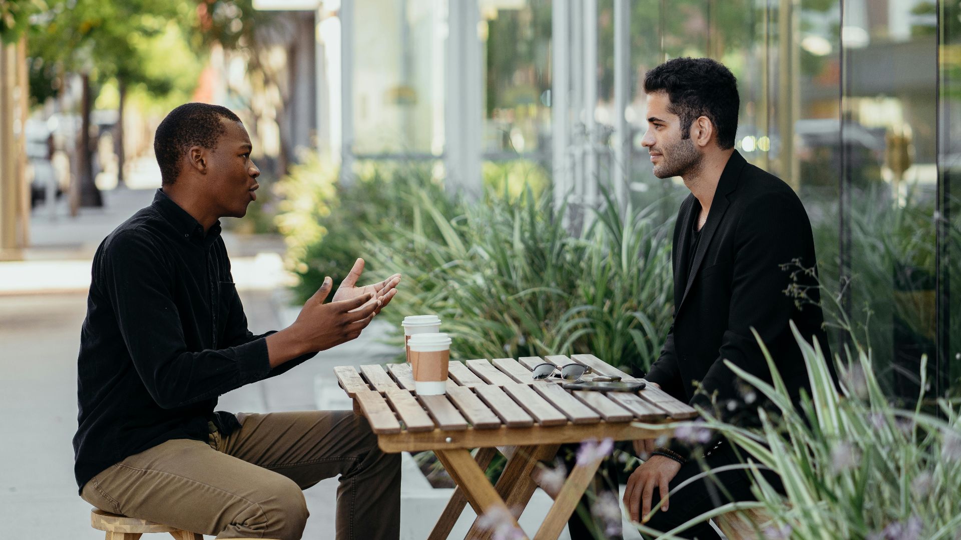 Two men having a business meeting at an outdoor café setting.