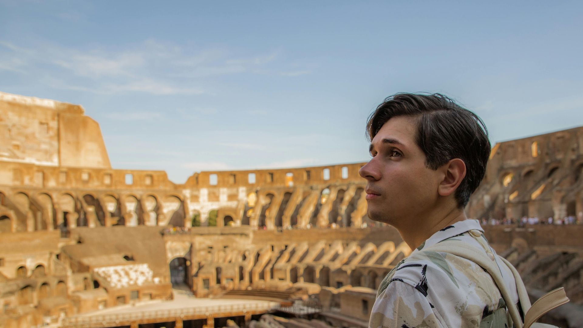 A young male tourist with a camera explores the historic Colosseum in Rome, capturing the ancient architecture.