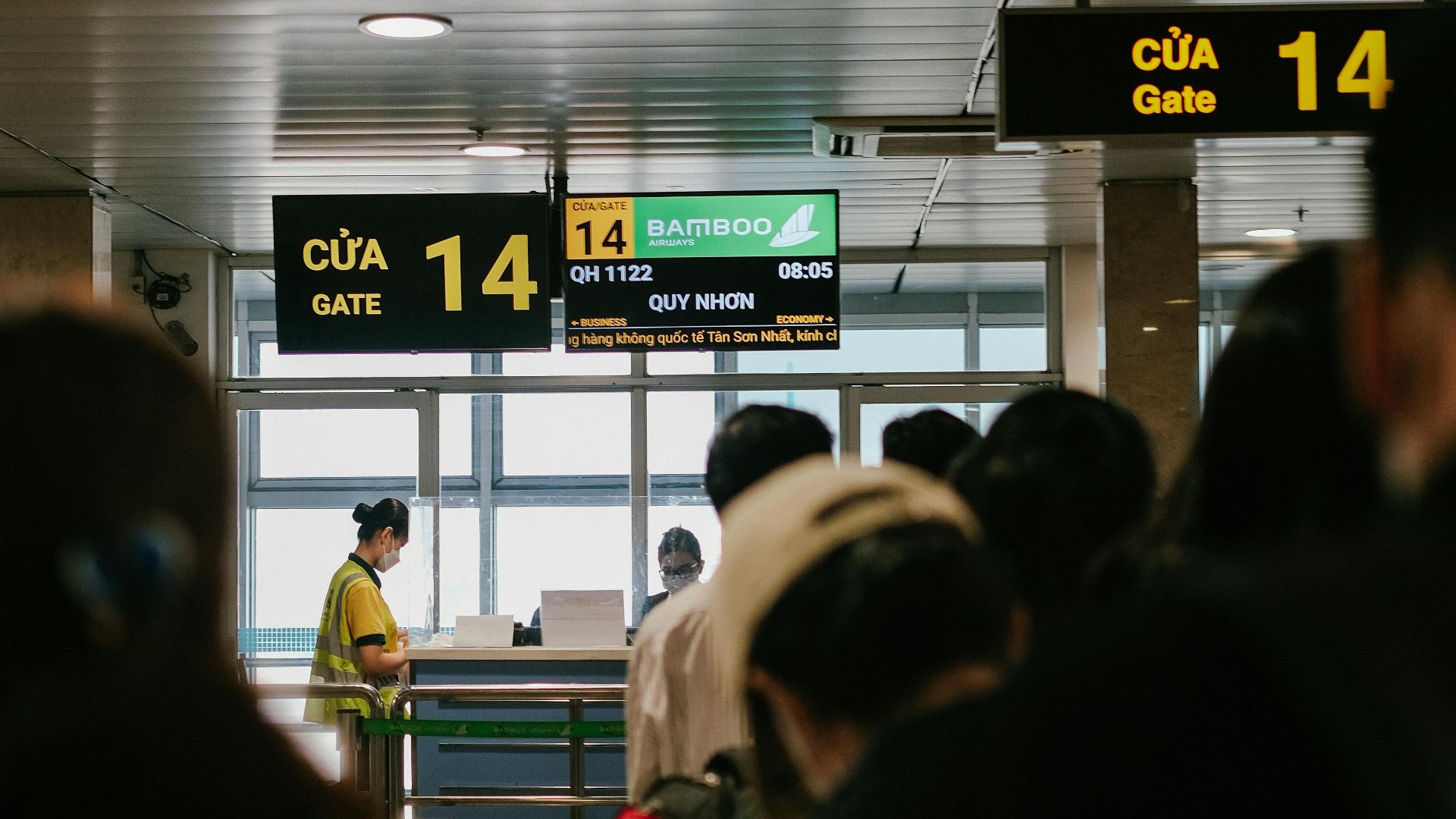 People standing in line at an airport gate, waiting to board a flight.
