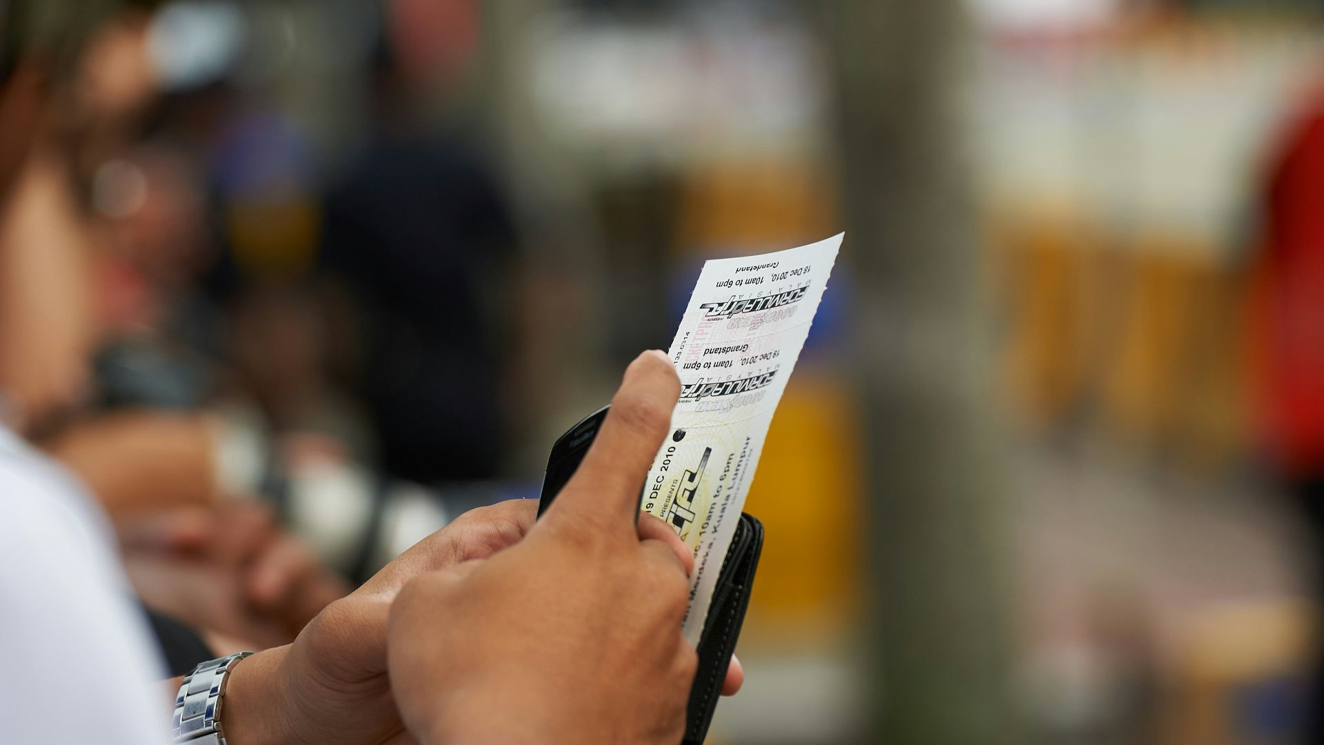 Person holding a lottery ticket with blurred background