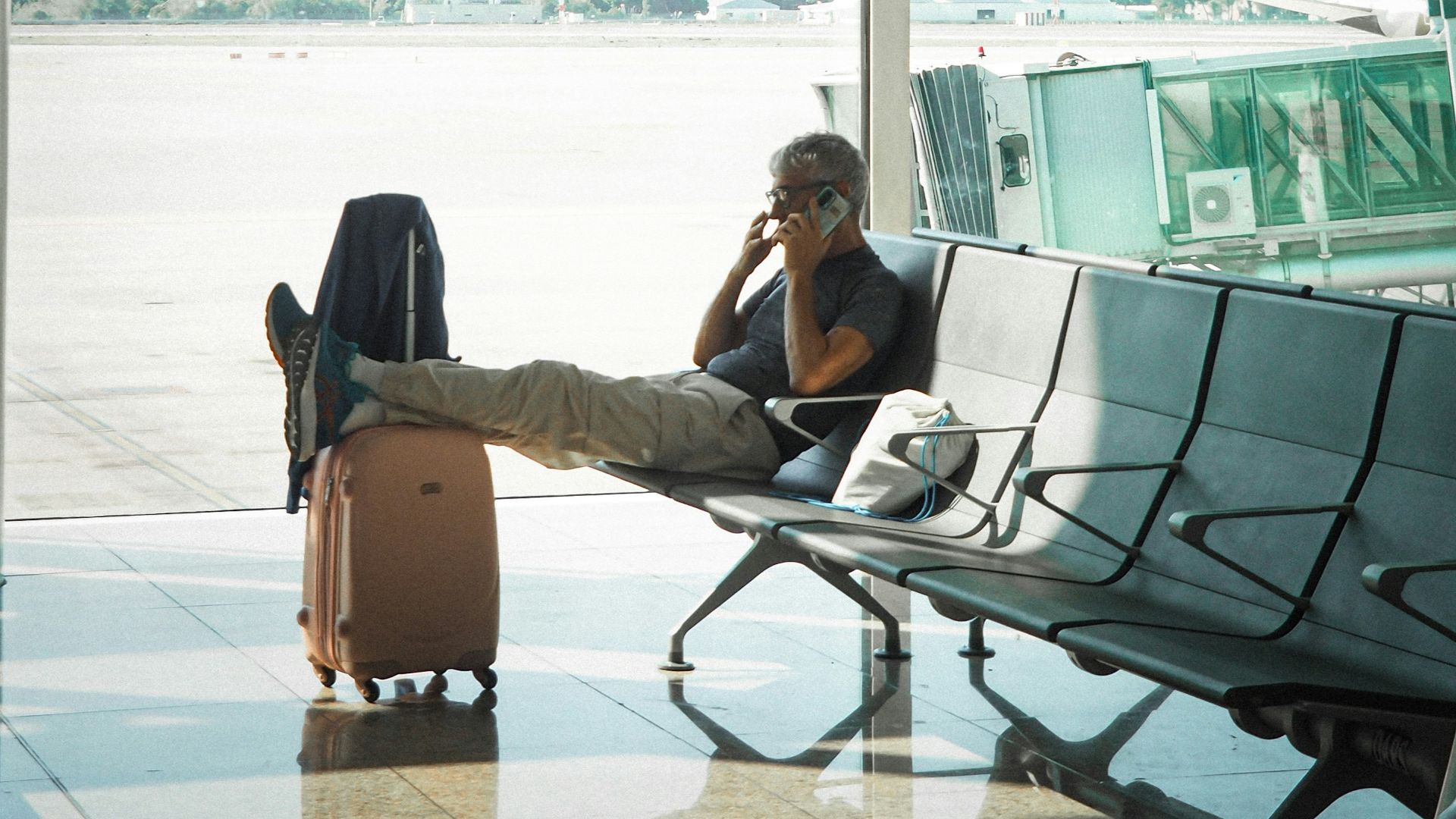 Man talking on phone in airport waiting area