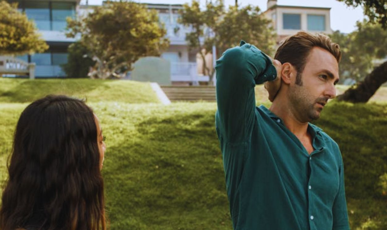 Man in Green Long Sleeves Standing Beside a Woman