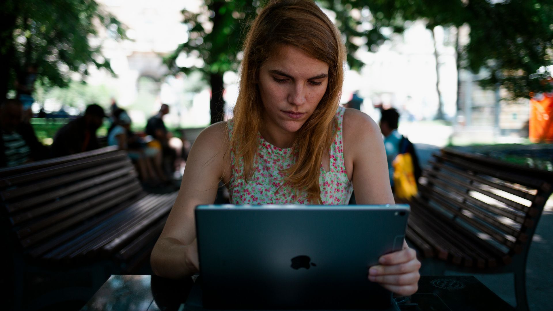 woman sitting on chair while using silver iPad