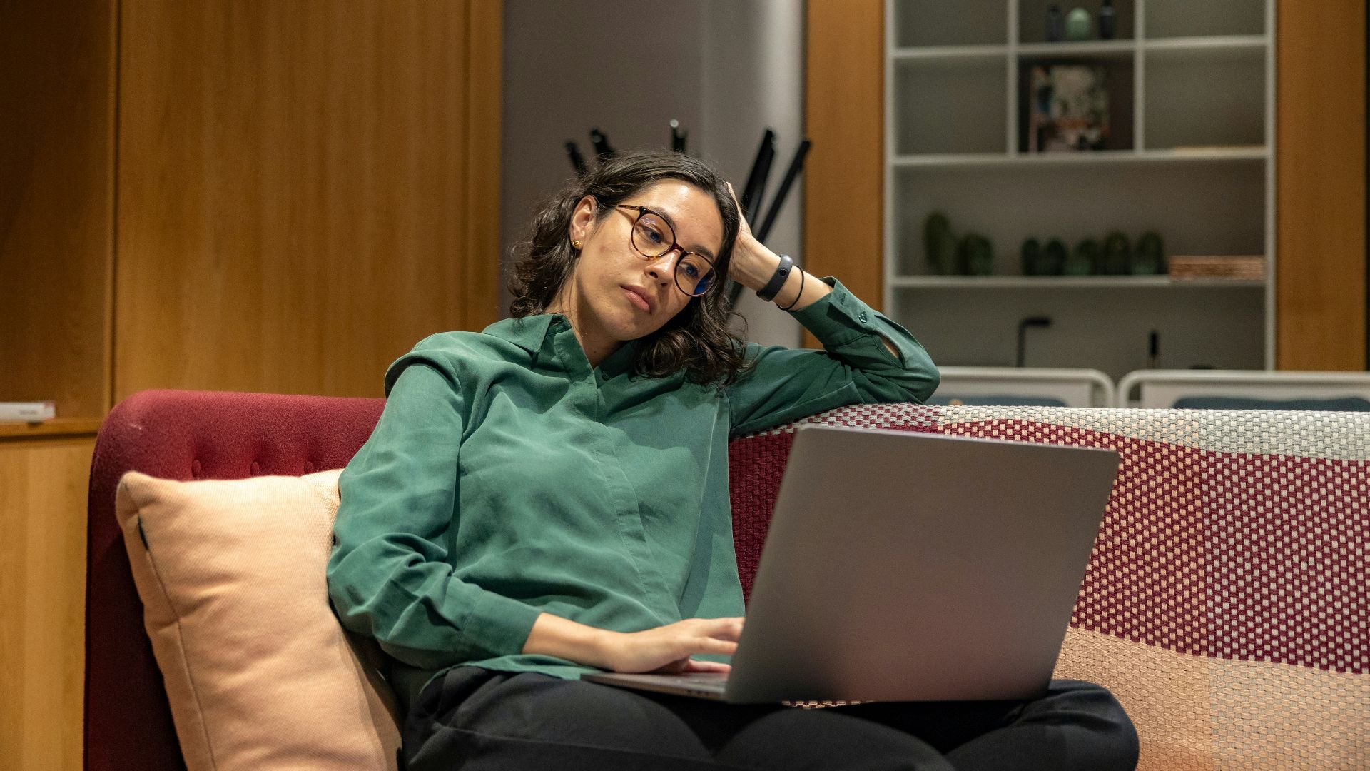 a woman sitting on a couch using a laptop computer