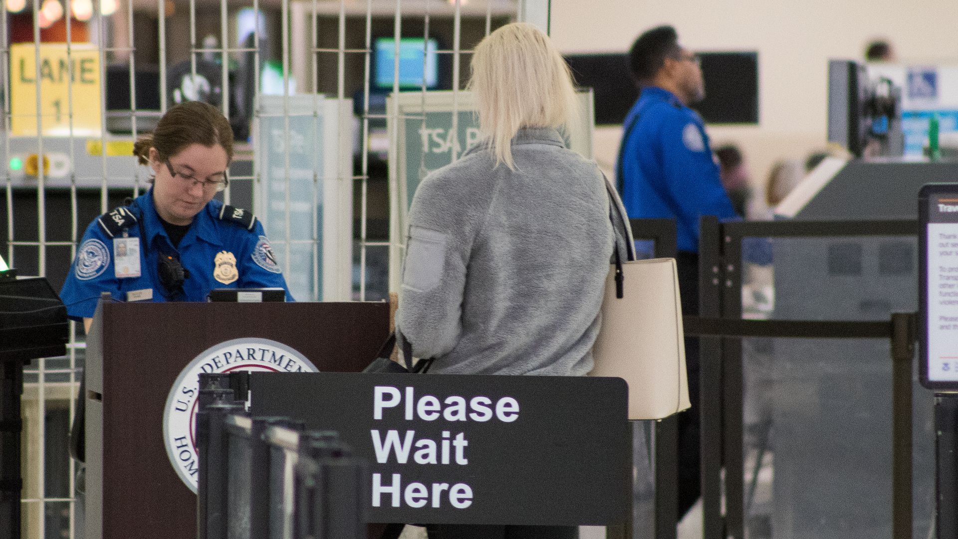 A Transportation Security Administration agent at a checkpoint verifying passenger identification, John Glenn Columbus International Airport