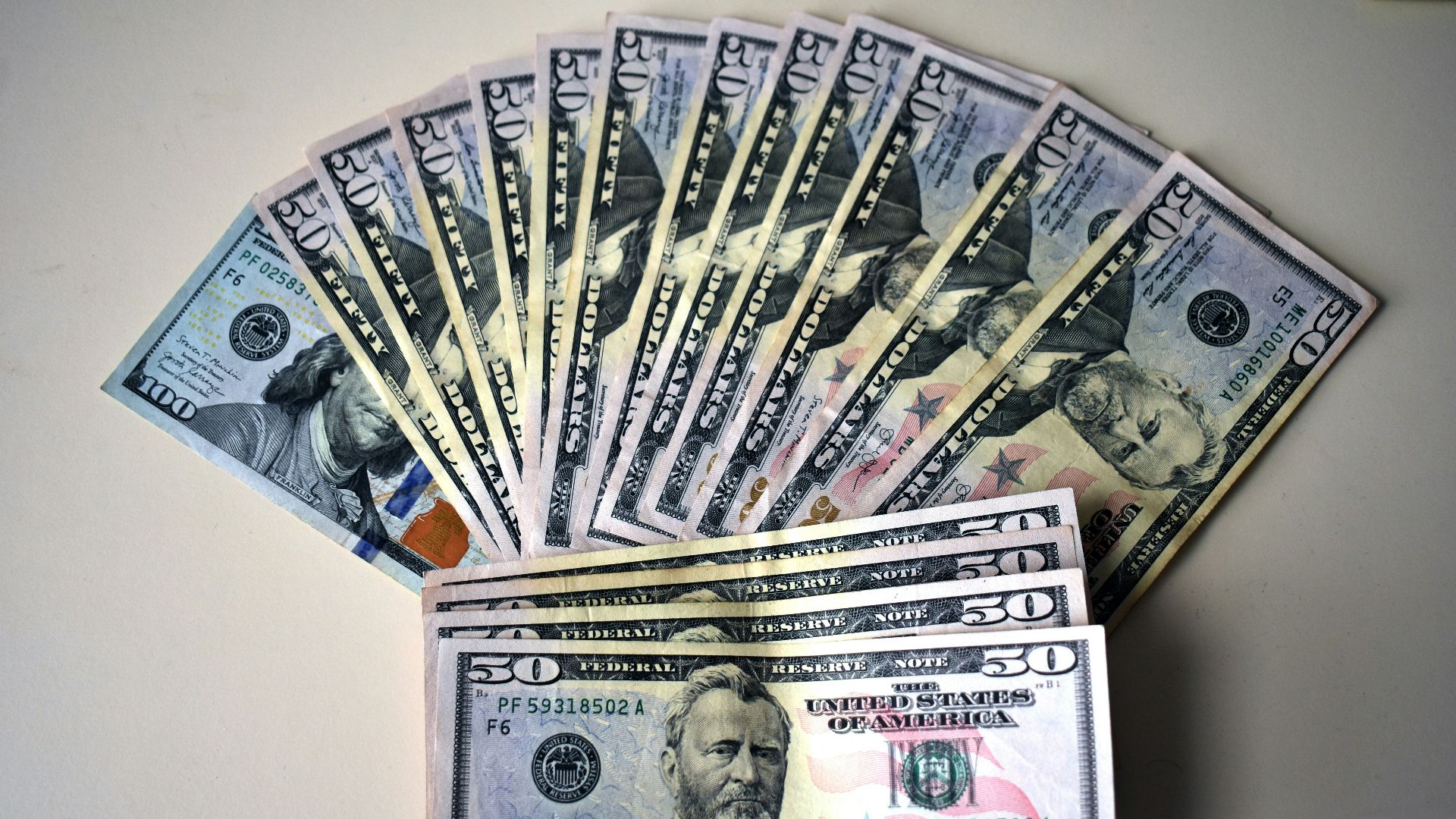 Fan of fifty dollar bills on a white surface