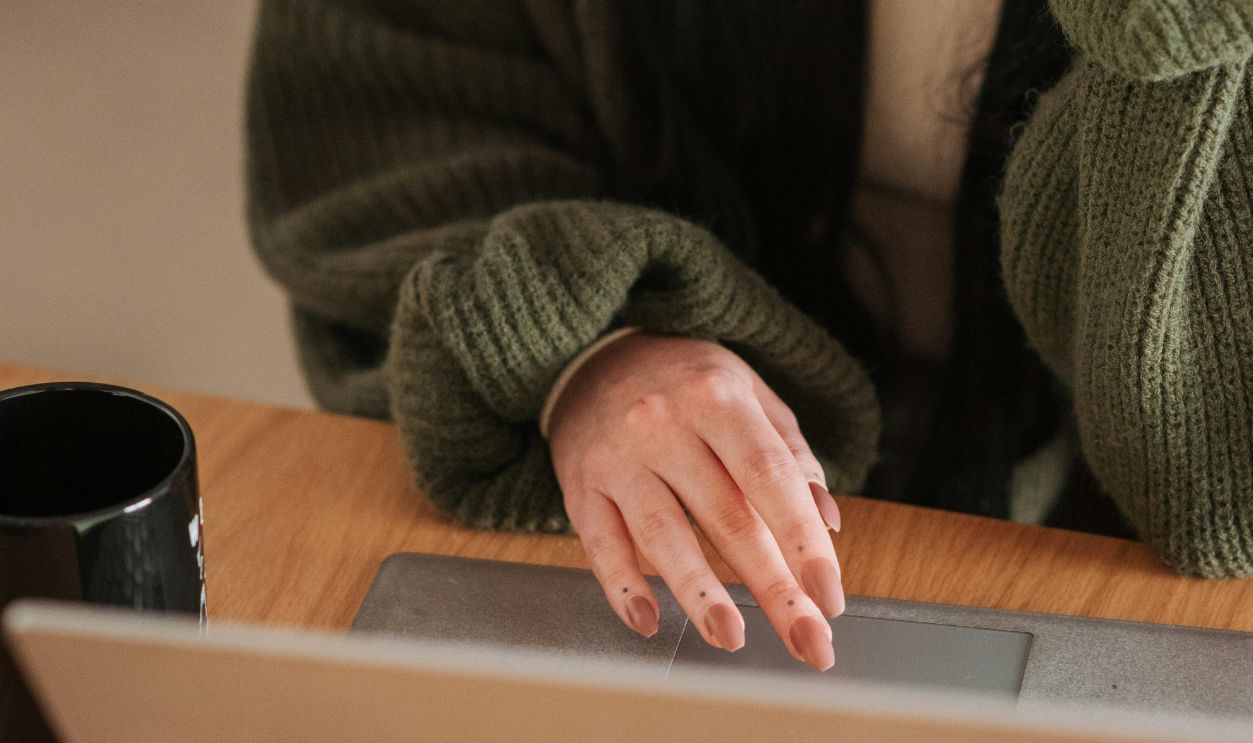 Crop distance worker surfing internet on laptop at home