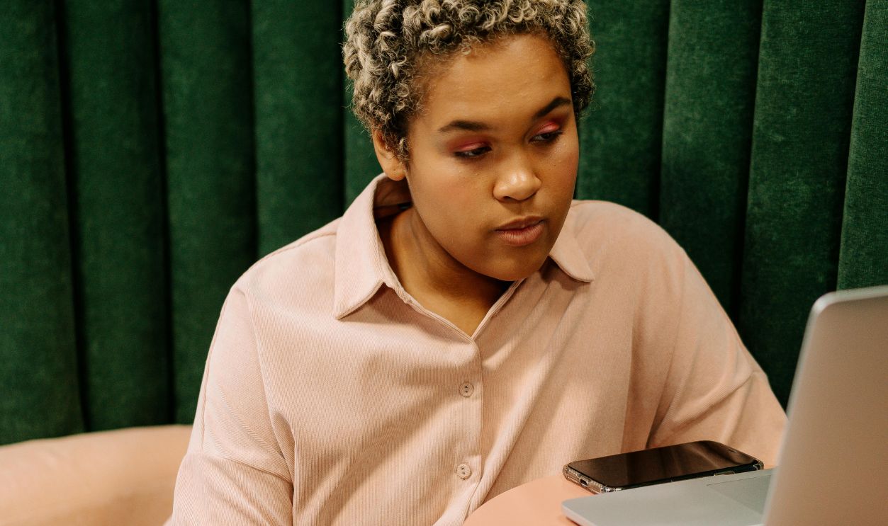 Woman Pink Long Sleeves Using a Laptop