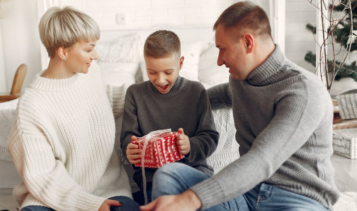 A Boy Unboxing Gift Besides His Parents