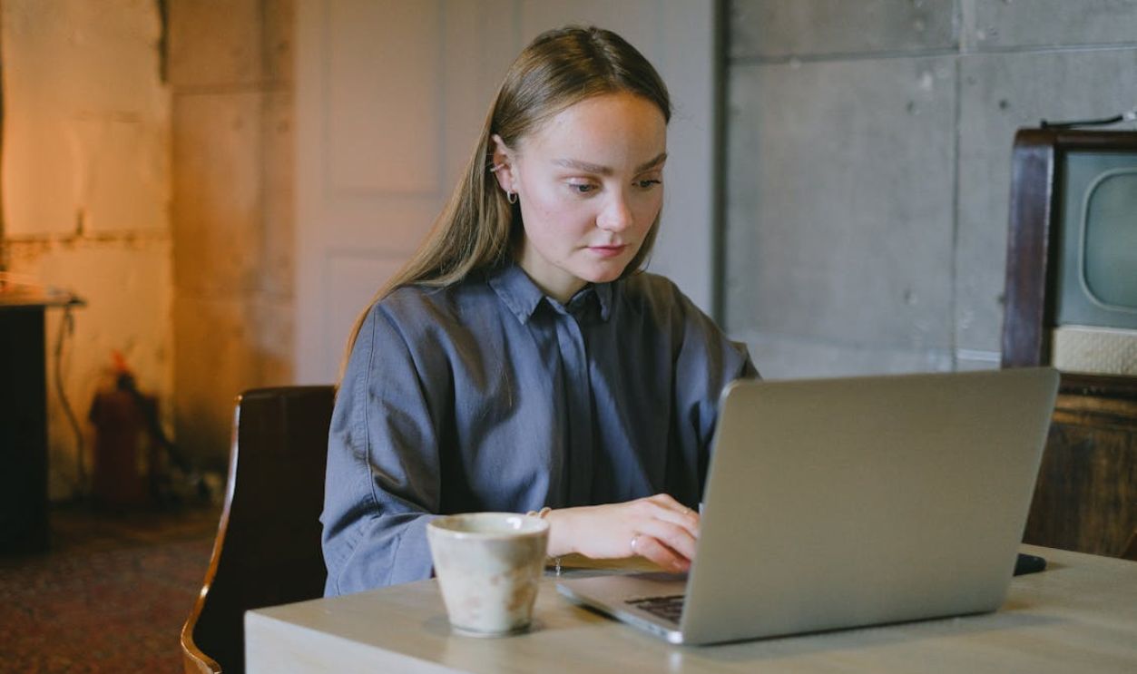 Serious female freelancer using netbook in workspace