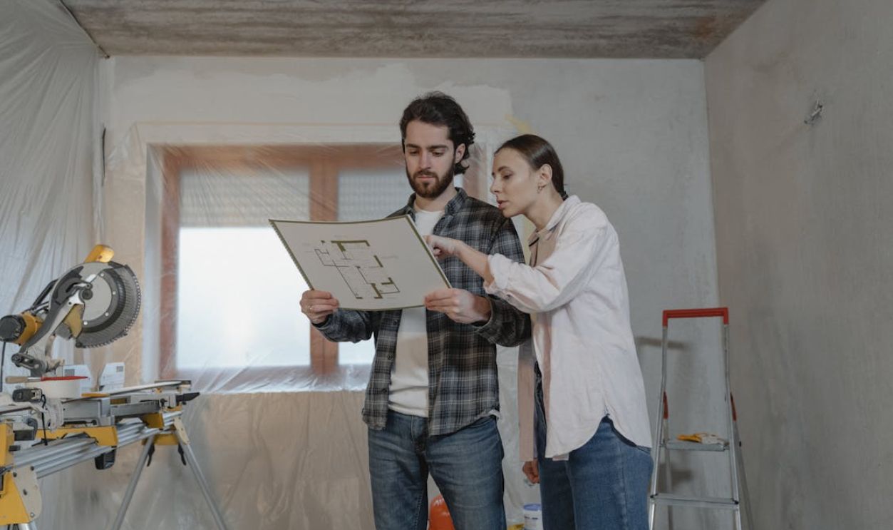 A Man and a Woman Looking at a Floor Plan