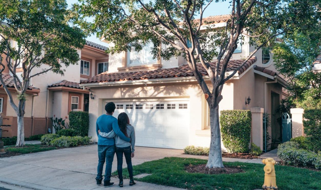 Couple Standing In Front of their House