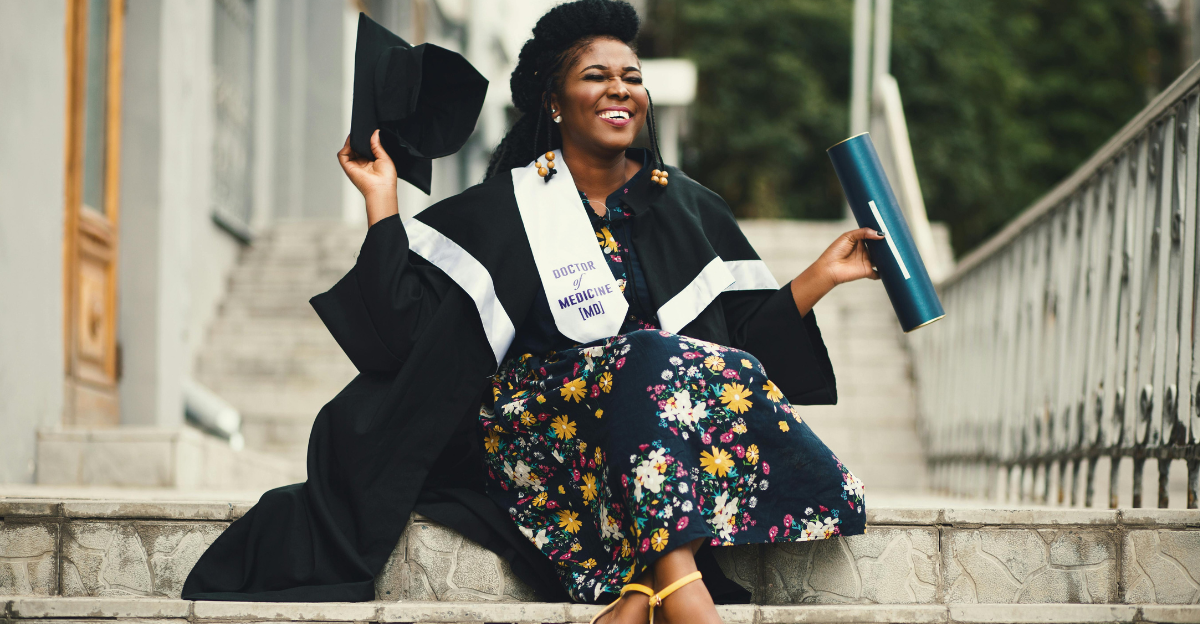 photo/photo-of-woman-wearing-academic-dress-and-floral-dress-sitting-on-stairway