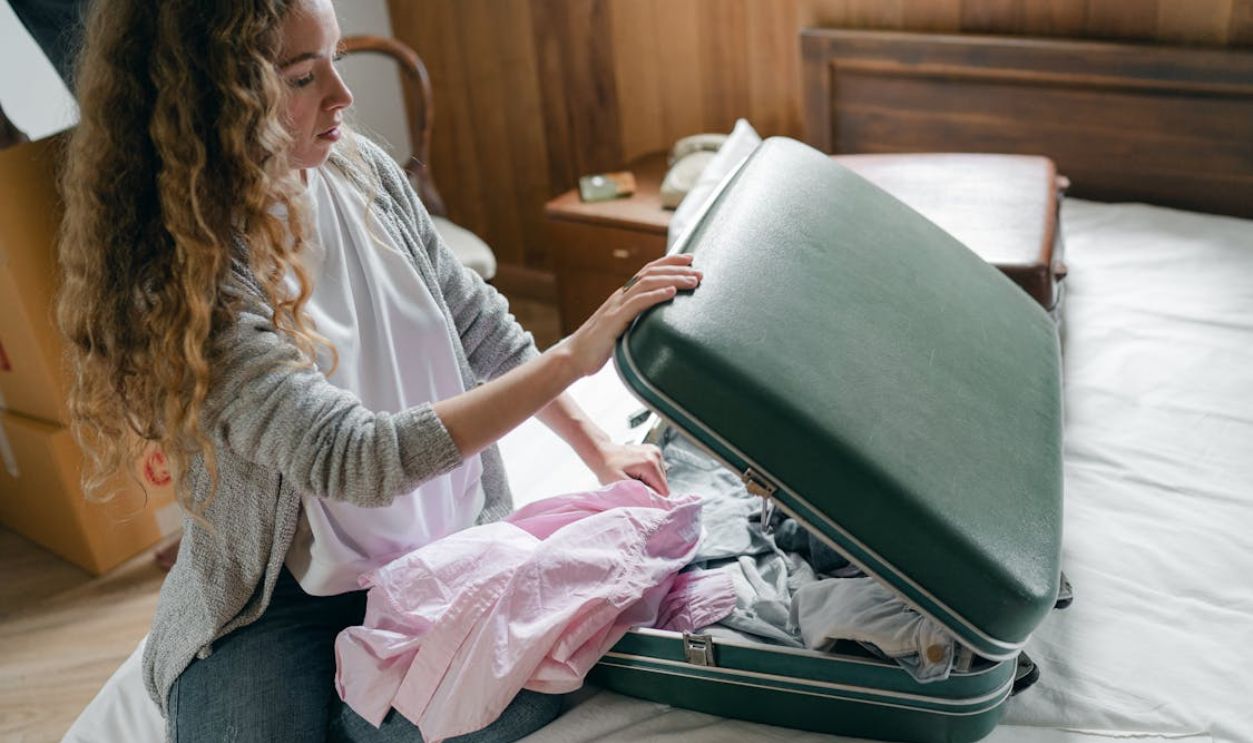 Focus woman packing suitcase on bed