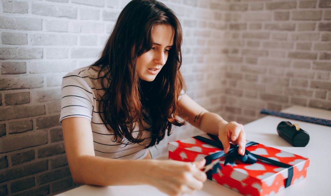 Woman Sitting and Wrapping Gift