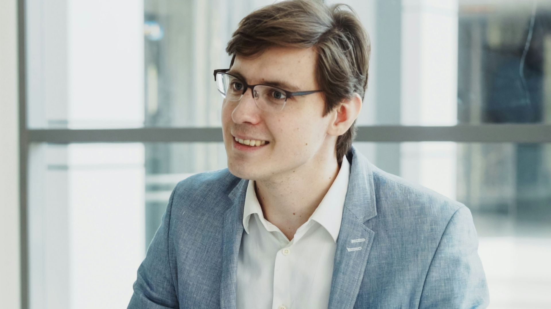 Man in suit interviews woman holding clipboard.
