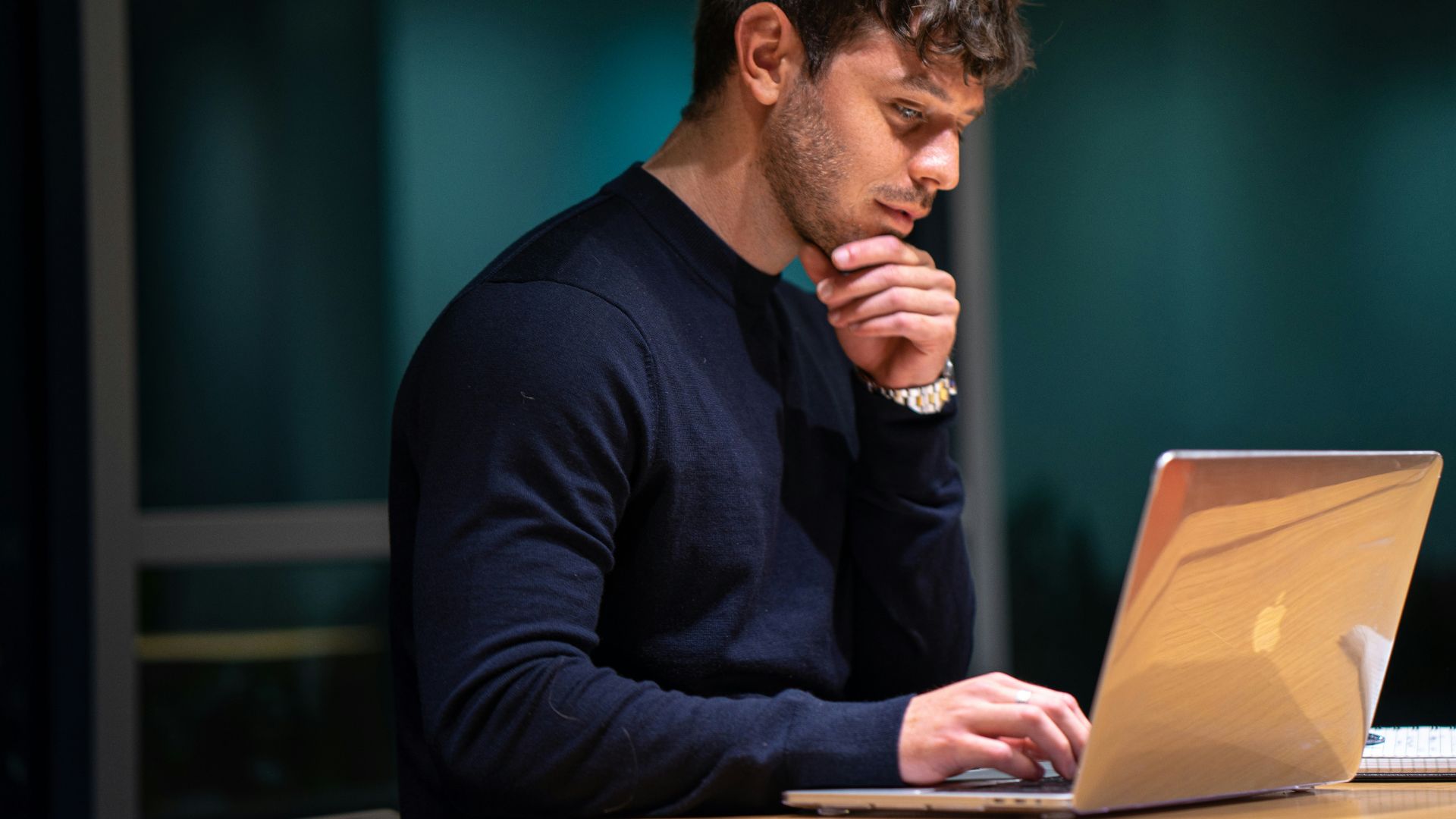 man in black long sleeve shirt sitting in front of macbook