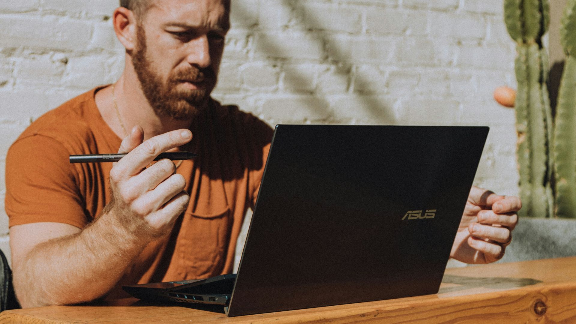 a man sitting at a table using a laptop computer