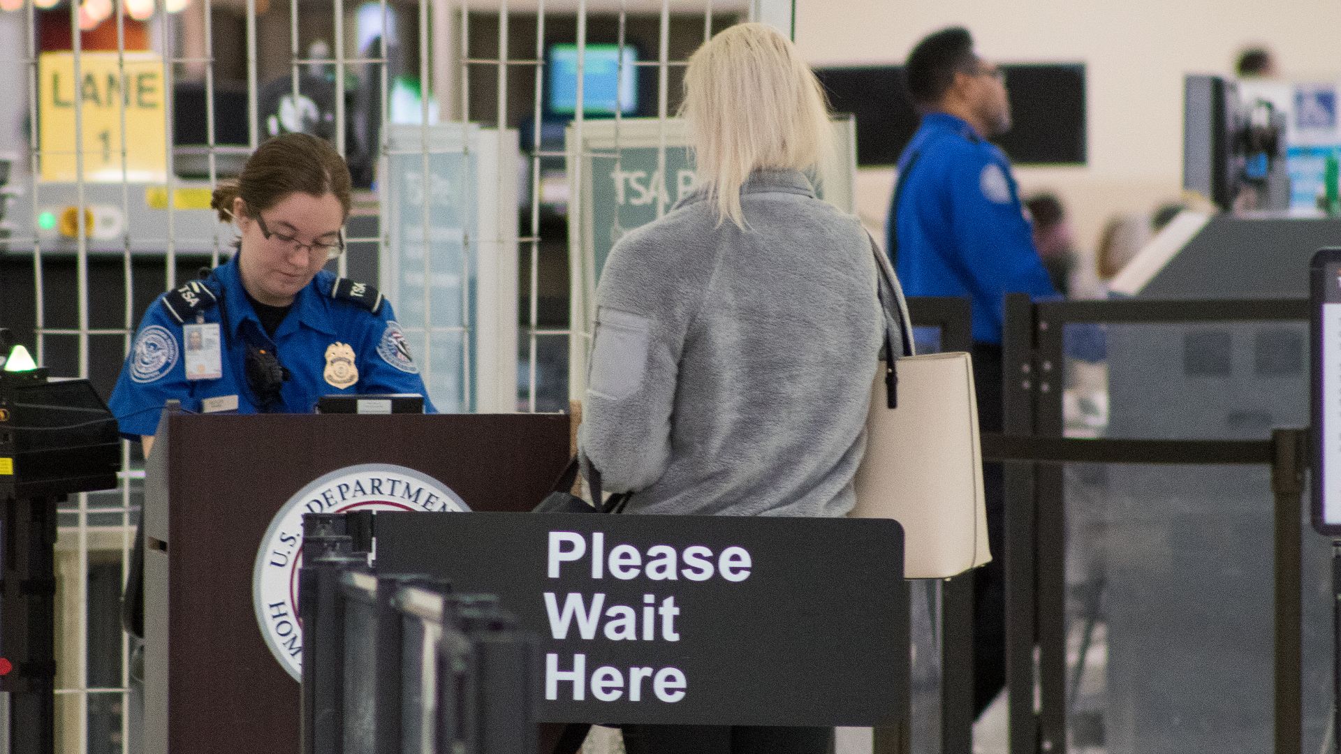 A Transportation Security Administration agent at a checkpoint verifying passenger identification, John Glenn Columbus International Airport