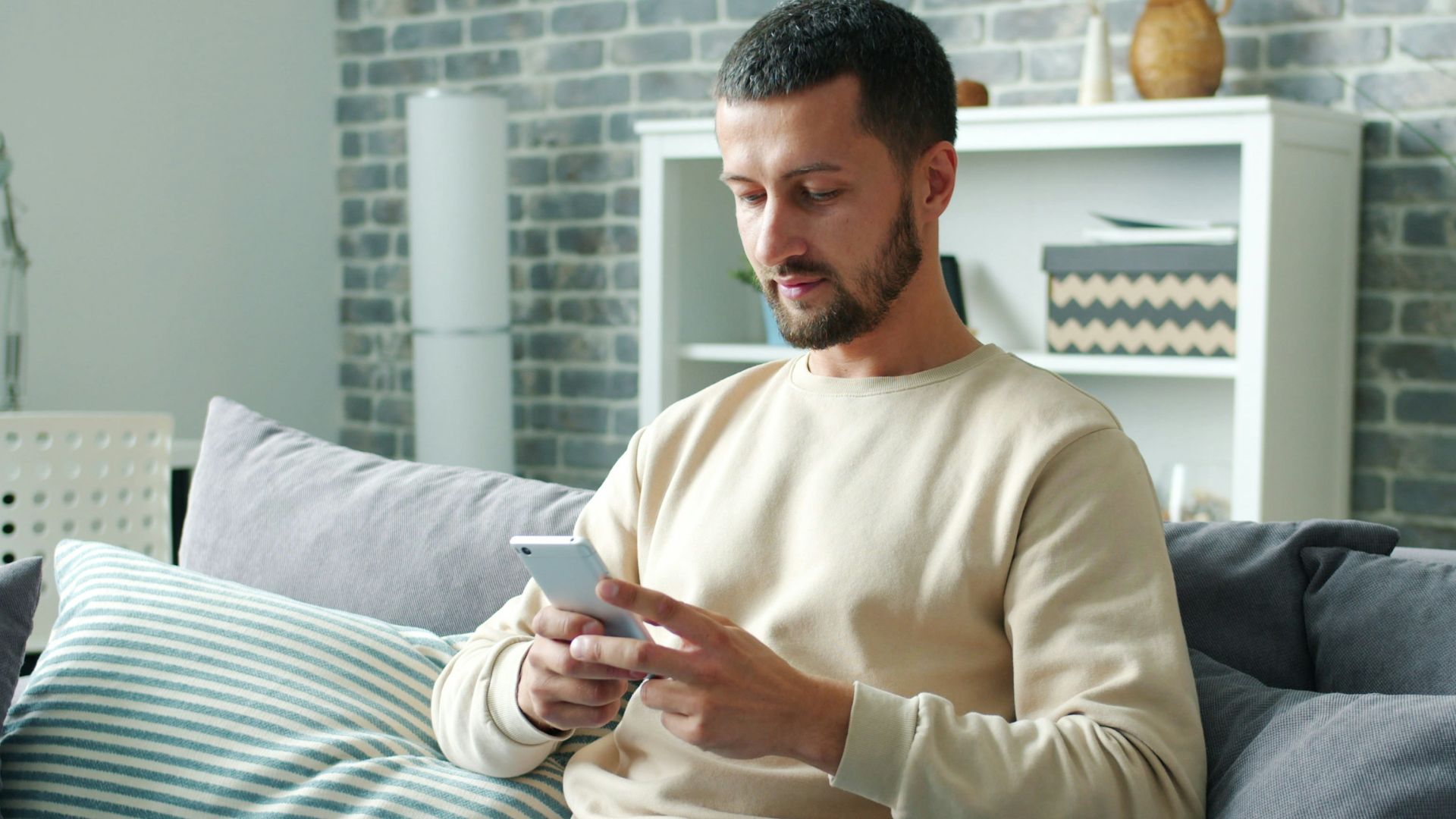 Man sitting on sofa using smartphone