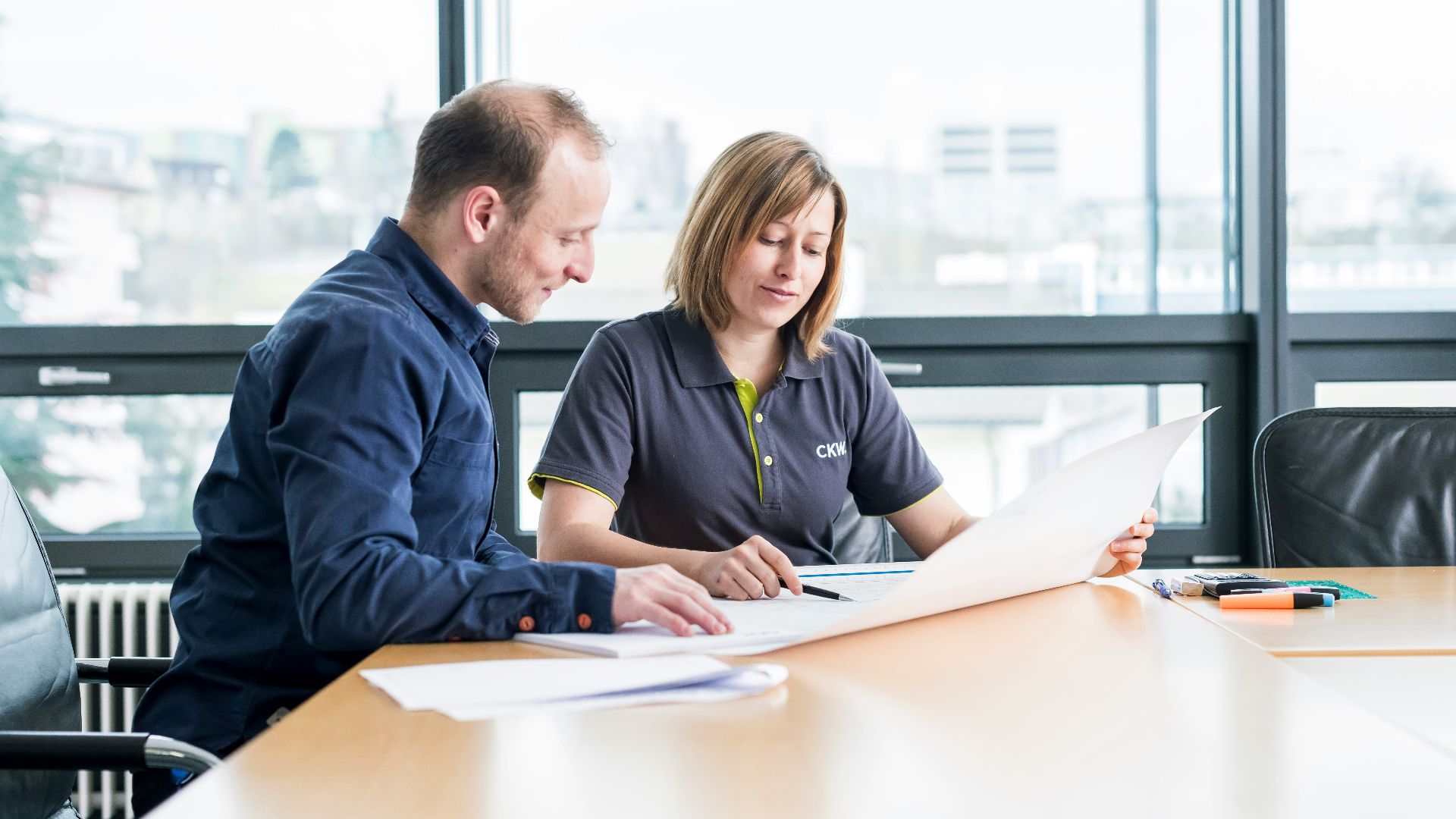 man in blue long sleeve shirt sitting beside woman in black long sleeve shirt