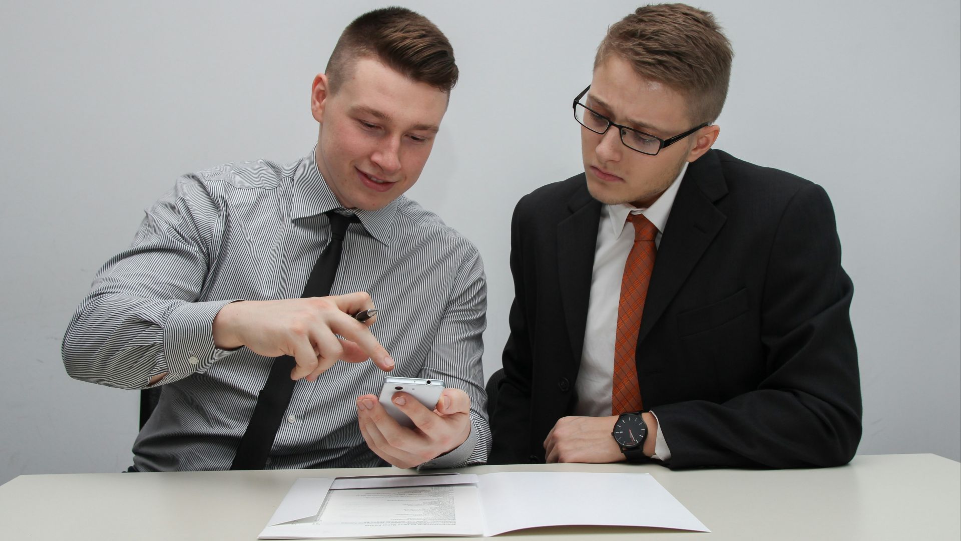 two man watching smartphone