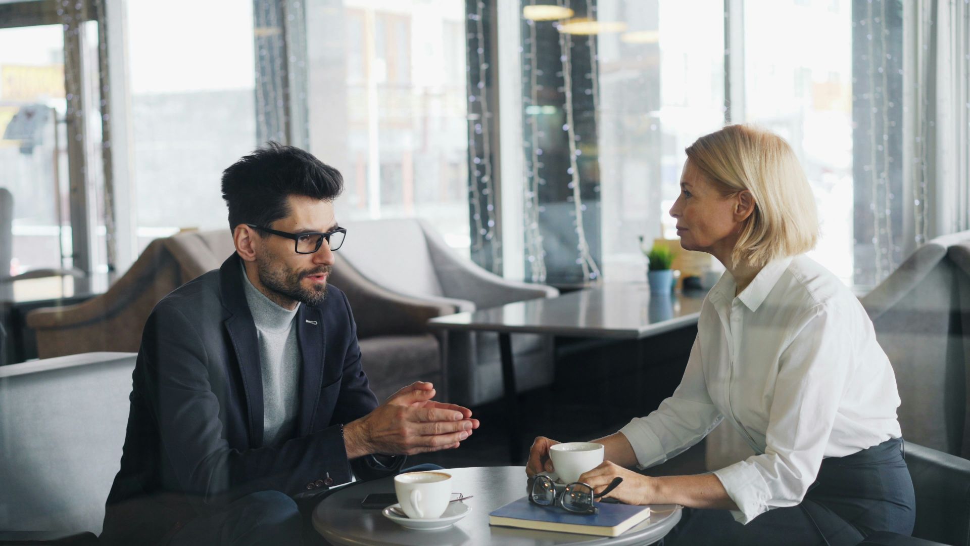 a man and a woman sitting at a table talking
