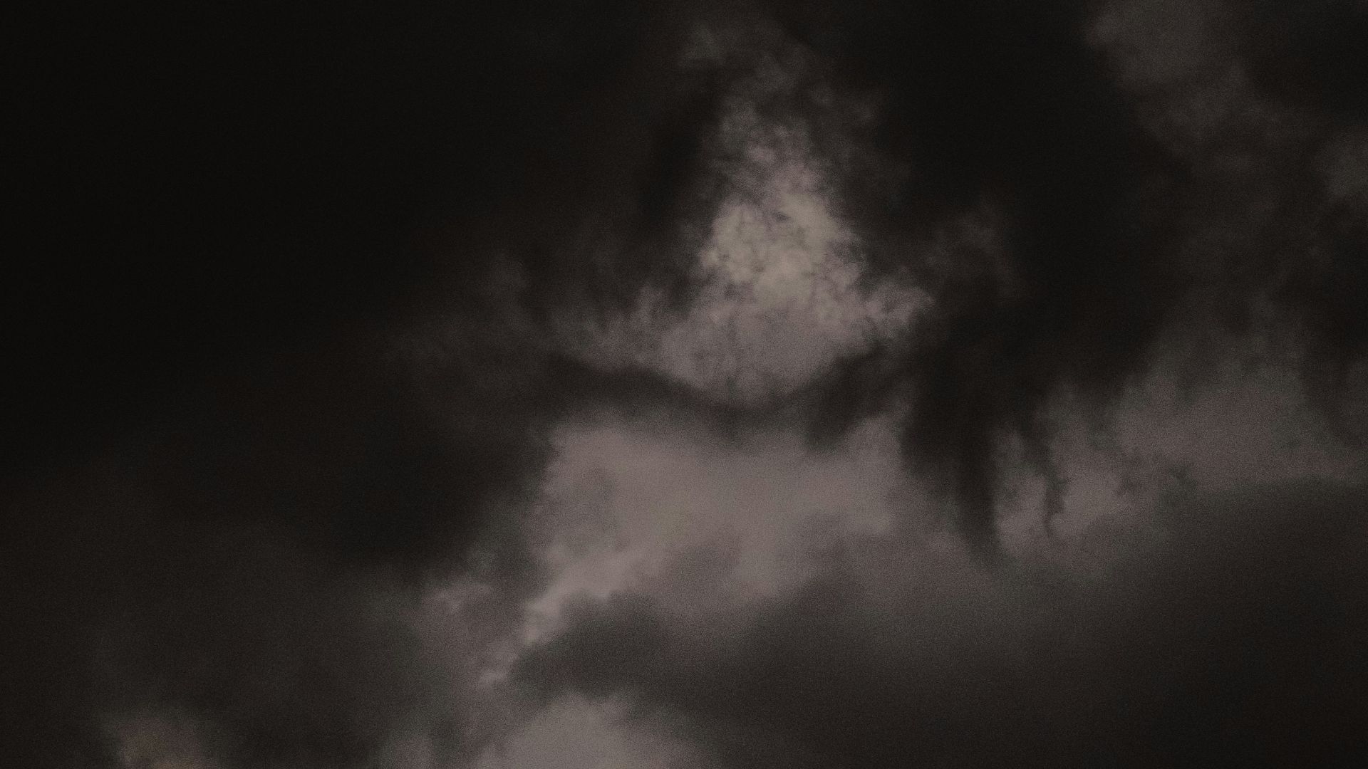 grayscale photo of mountain under cloudy sky