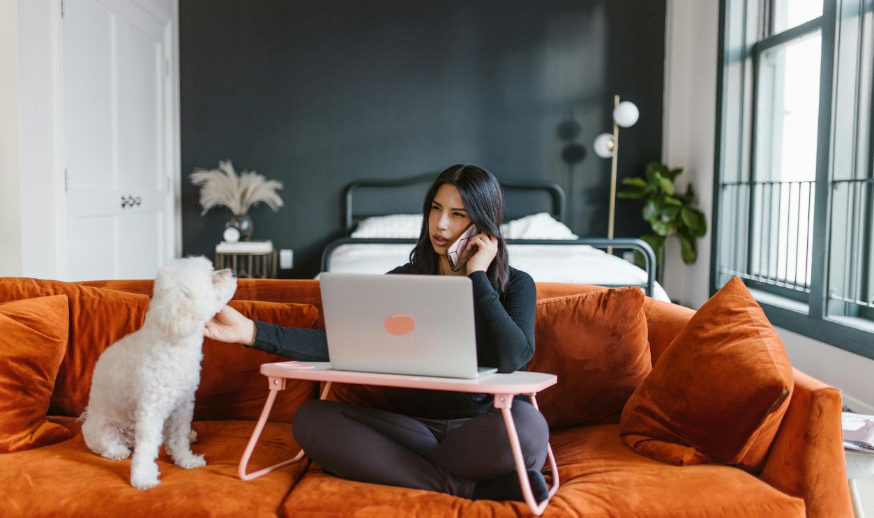 Woman Petting a Dog While on Phone Call