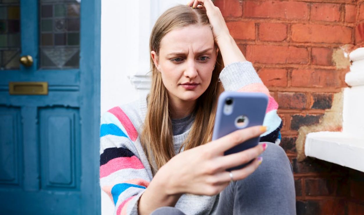 Woman Sitting on Stairs Using Phone
