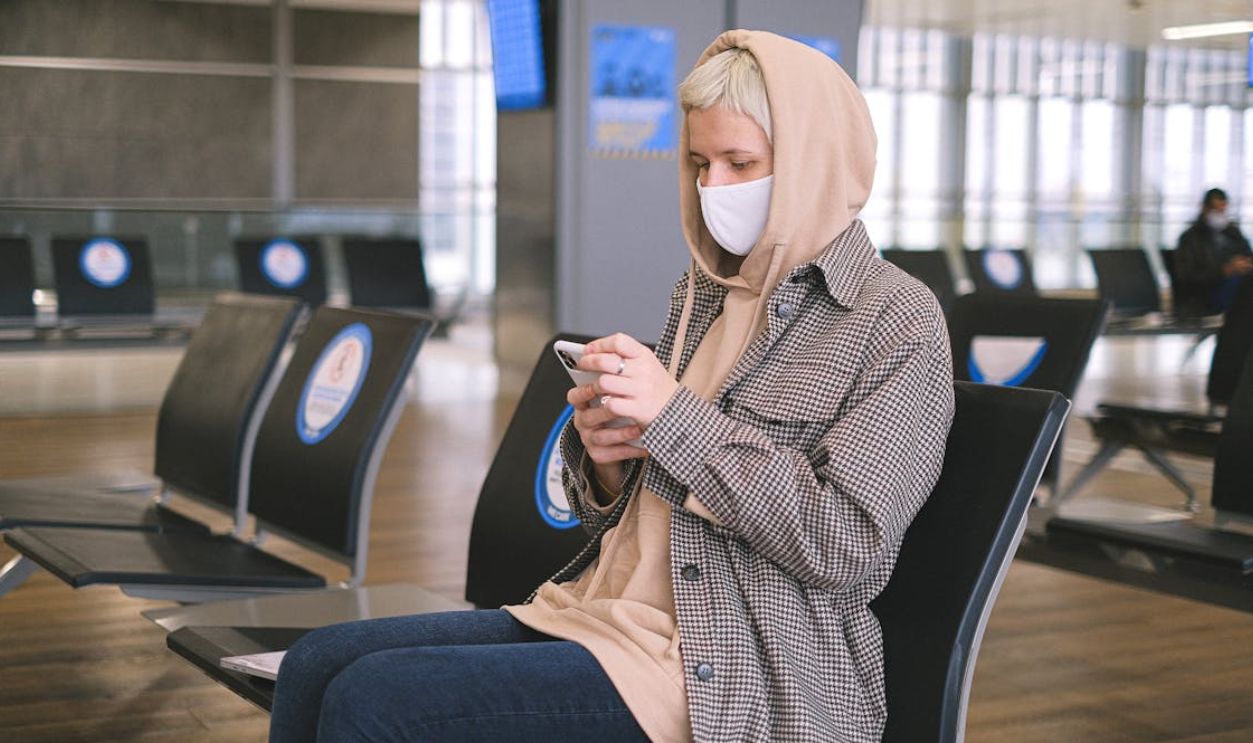 Woman in Black and White Checkered Long Sleeve Shirt and Brown Hoodie Sitting on Black Chair