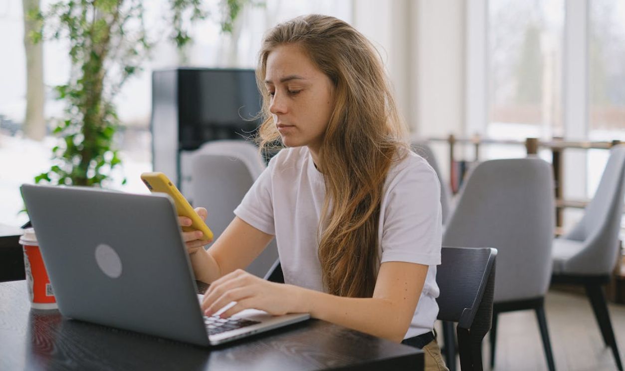 A Woman in White Shirt Using a Smartphone