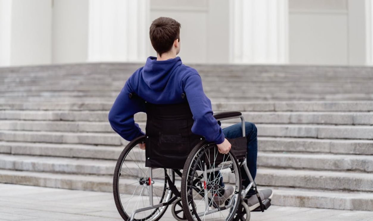Close-Up Shot of a Man Sitting on a Wheelchair