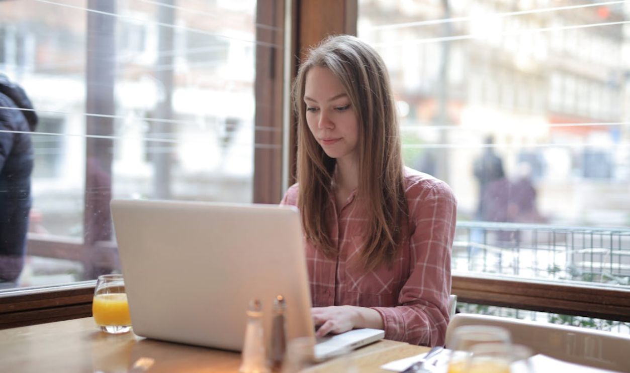 Woman in Pink Shirt Using Laptop